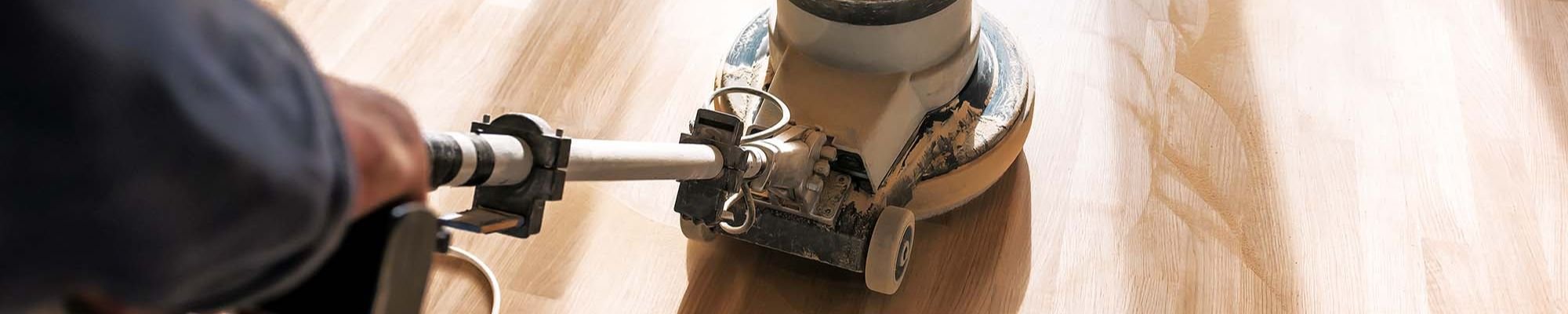 A person sanding down a hardwood floor
