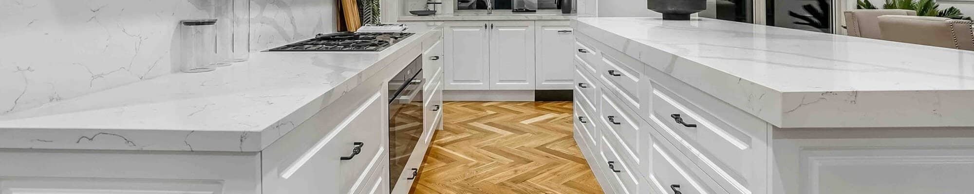 Hardwood flooring in a bright kitchen with white cabinets